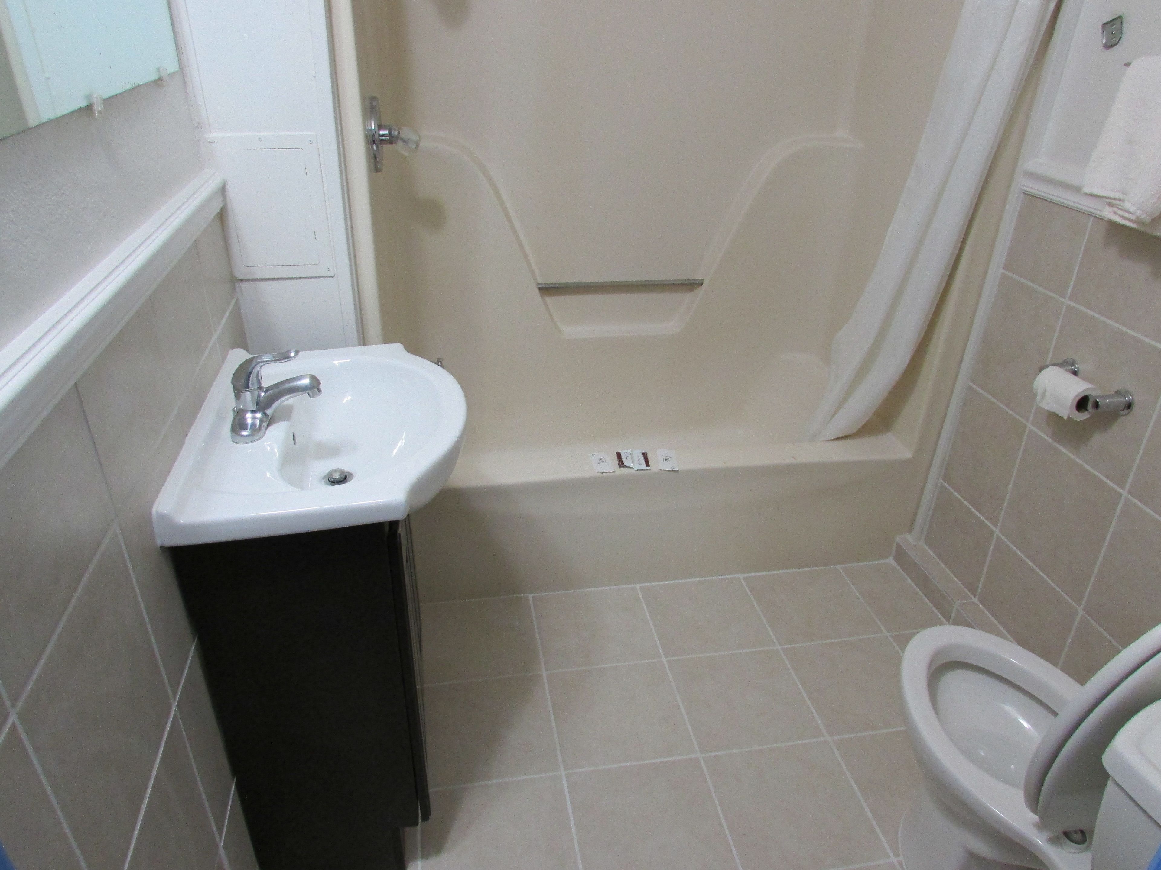 Un baño pequeño con lavamanos, inodoro y bañera.