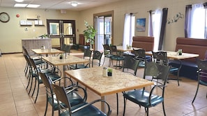 A restaurant with multiple tables and chairs, a clock on the wall, and a closed sign on the door. - Lacombe Motor Inn (Lacombe)