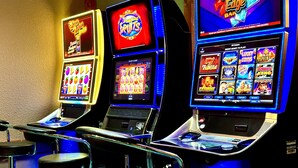 A row of slot machines with various game screens, including "Lucky Coins" and "Power Keno". - Lacombe Motor Inn (Lacombe)