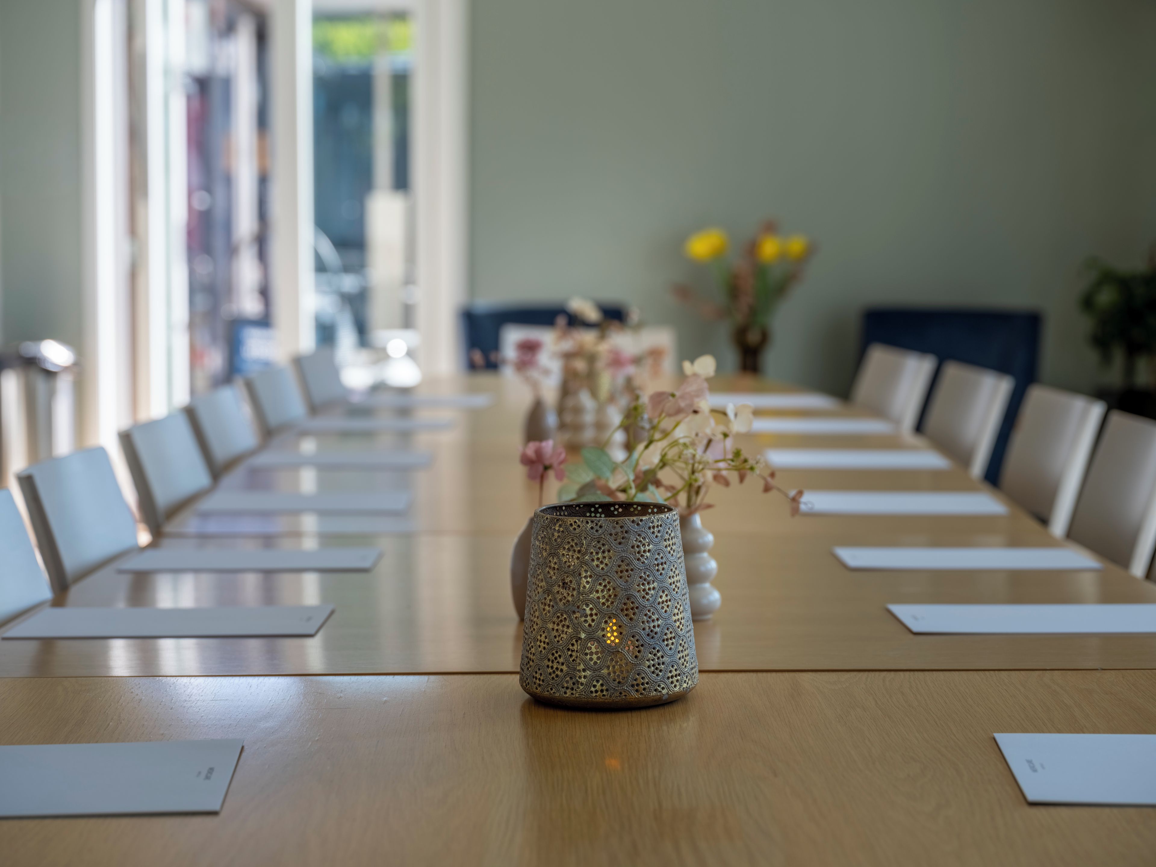 Ein Konferenztisch mit einer dekorativen Vase in der Mitte, umgeben von Stühlen.