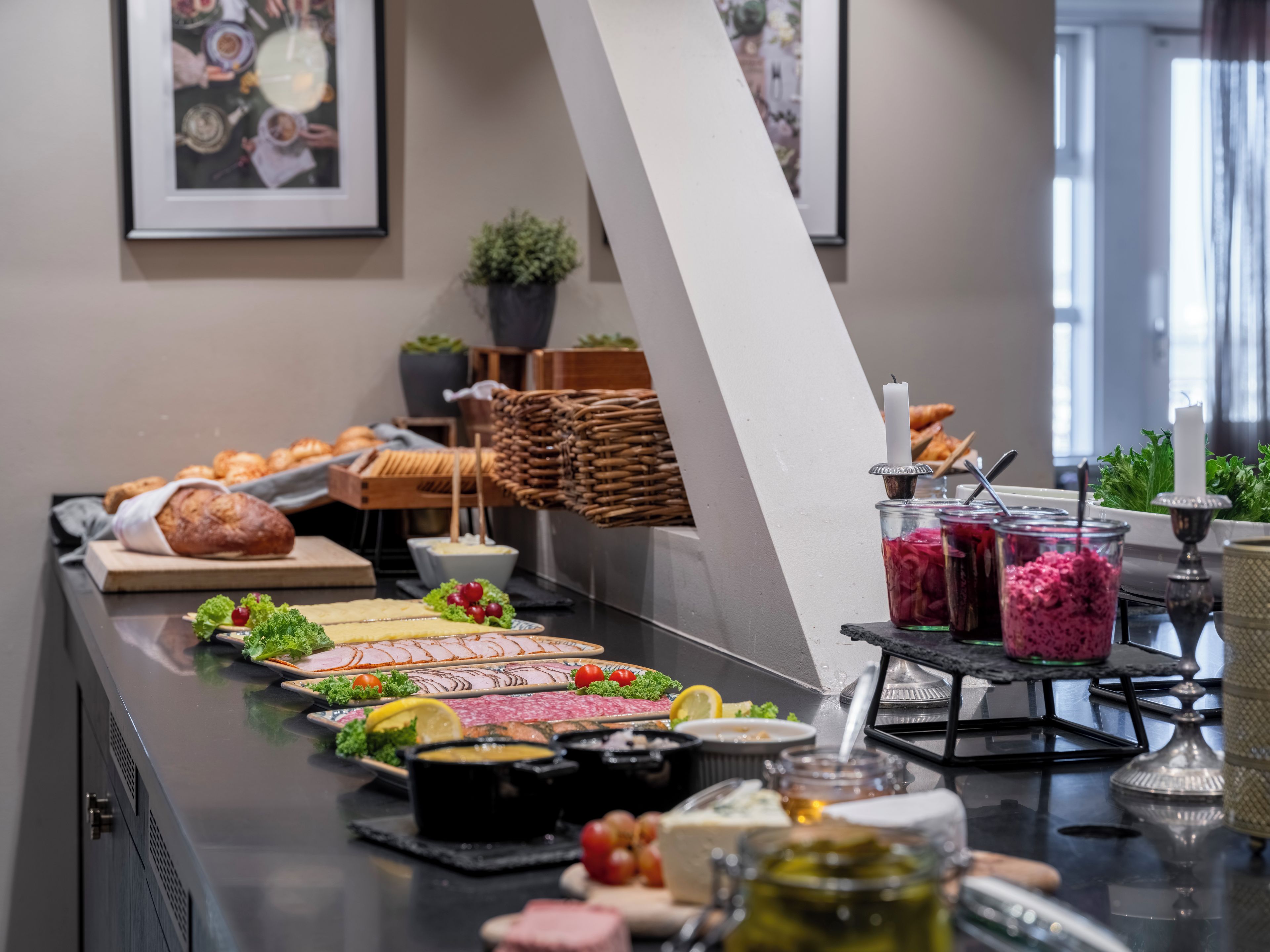A buffet setup with various food items and a decorative wall.
