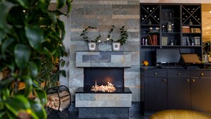 A modern kitchen with a stone fireplace, a wine rack, and a laptop on a desk. - Mercure Gothenburg (Vastra Frolunda)