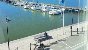 A marina with boats docked, a clear sky, and a flagpole with a flag. - Mercure Gothenburg (Vastra Frolunda)