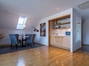 A modern kitchen with wooden cabinets, a microwave, and a small countertop. - Mercure Gothenburg (Vastra Frolunda)