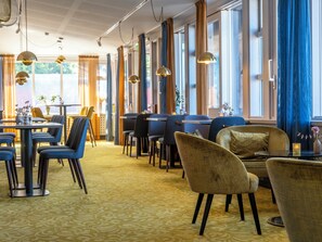 A restaurant interior with tables, chairs, and hanging pendant lights. - Mercure Gothenburg (Vastra Frolunda)