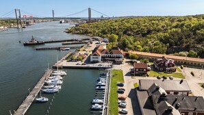 A marina with boats docked, a bridge in the background, and buildings with red roofs. - Mercure Gothenburg (Vastra Frolunda)