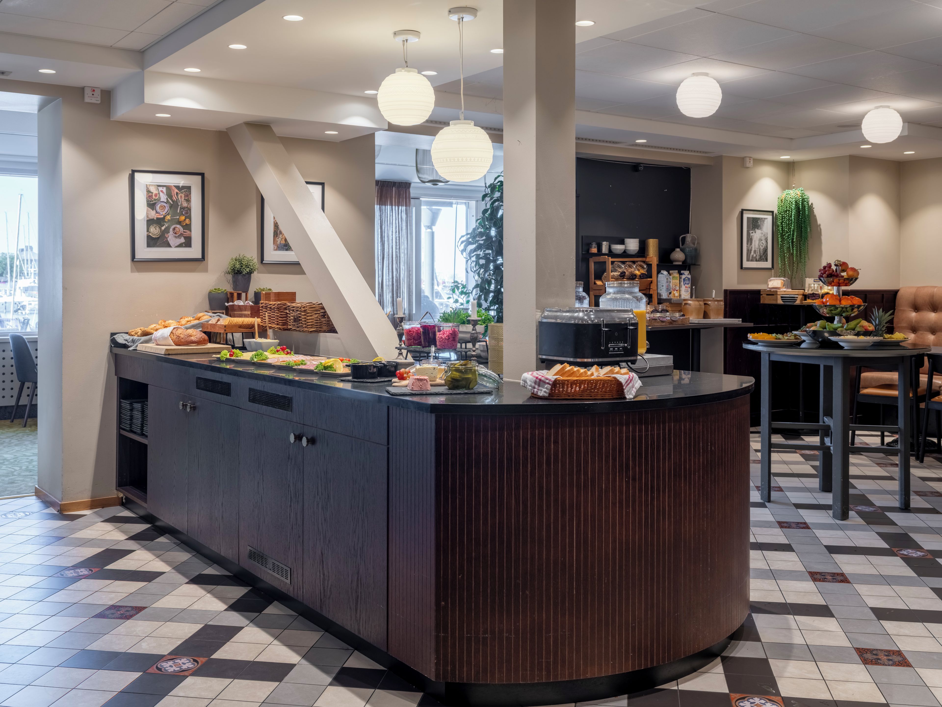 A buffet area with a variety of food items, a seating area with a table and chairs, and a large window providing natural light.