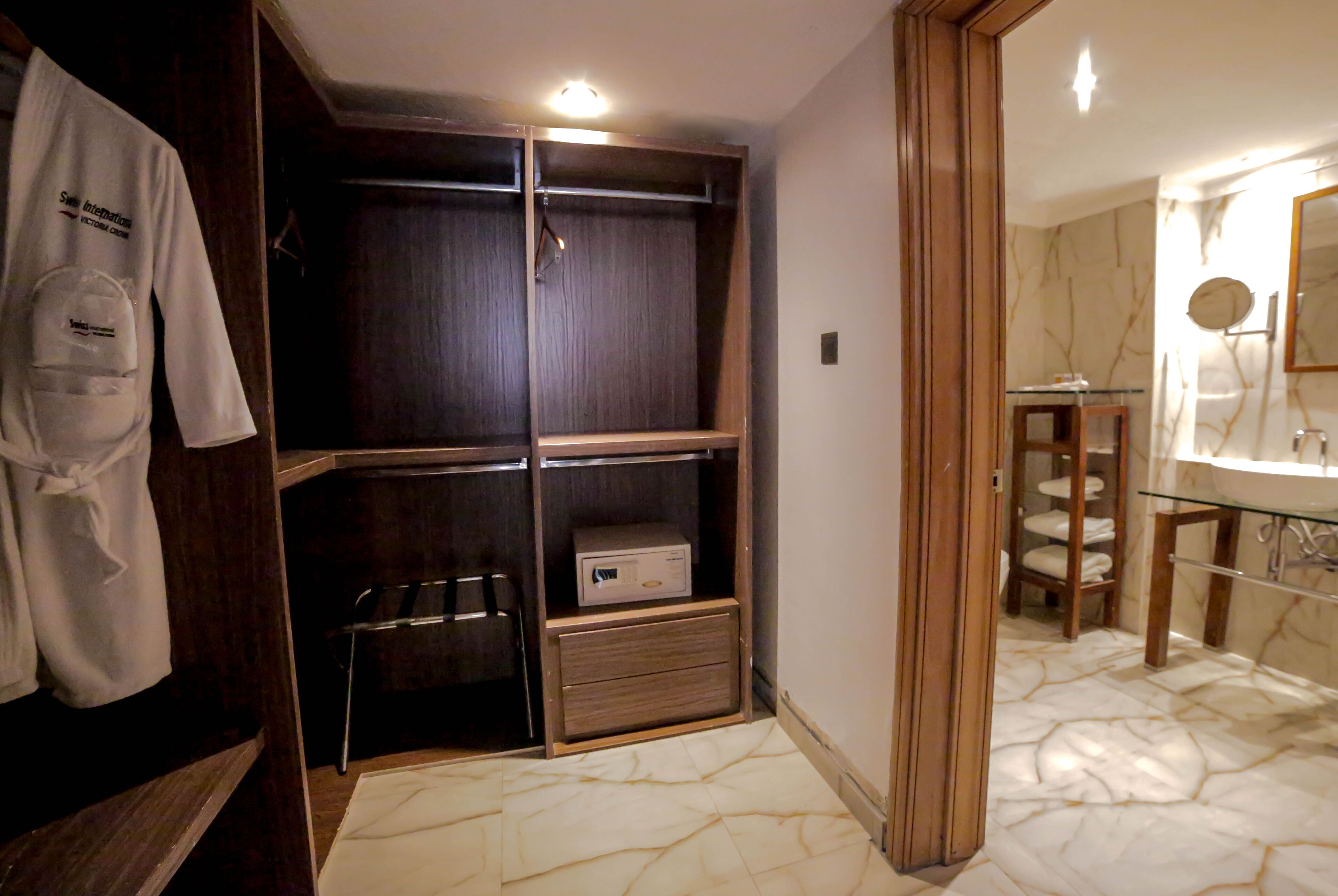 A walk-in closet with wooden shelves and a mirrored wardrobe.