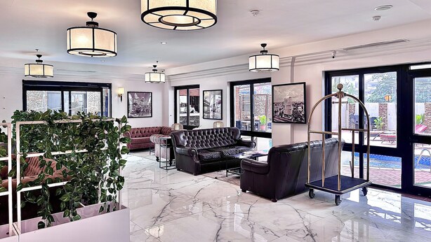 A spacious lobby with marble flooring, leather seating, large windows, and modern lighting fixtures. - Victoria Crown Plaza Hotel (Lagos)