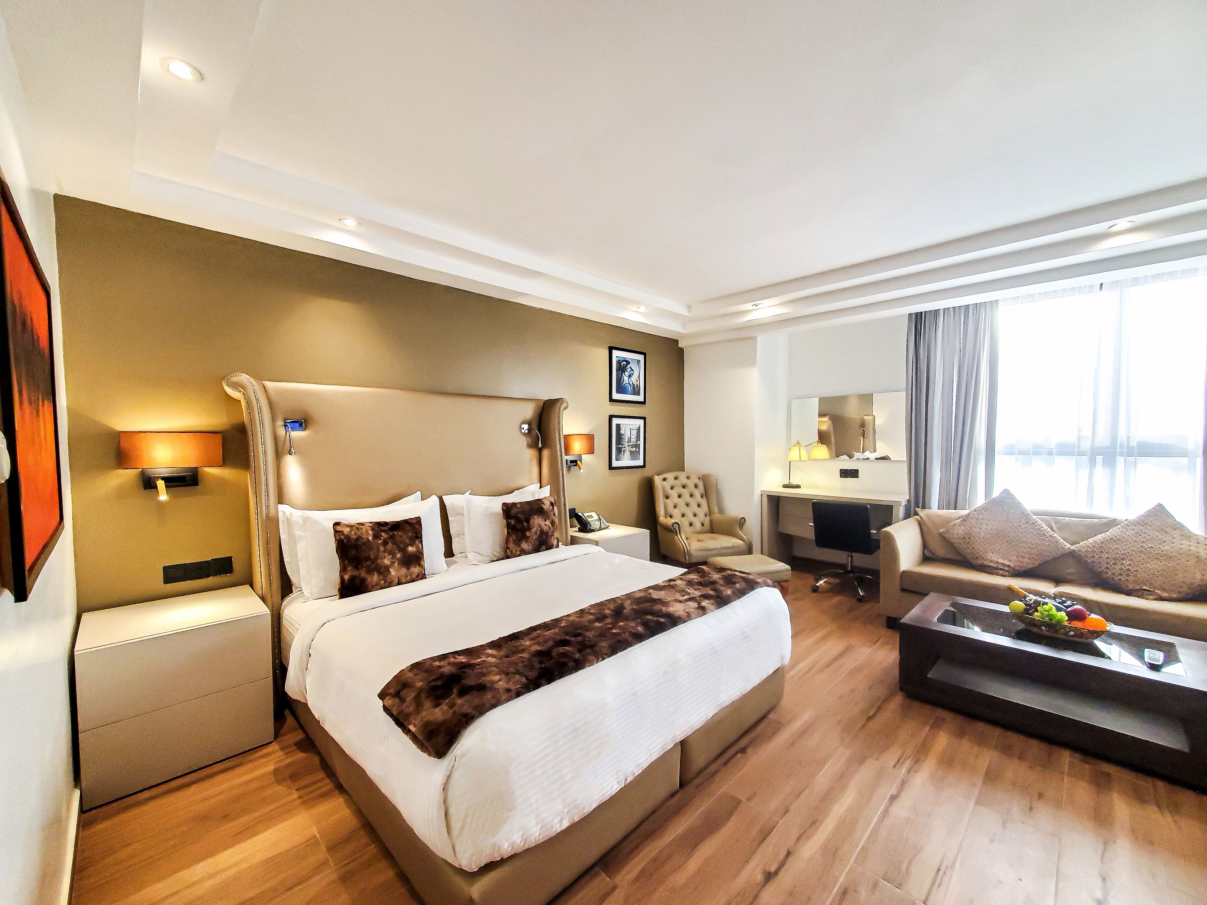 Une chambre d’hôtel avec un grand lit, un bureau, un canapé et une vue sur l’eau.
