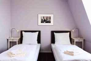 A twin room with two beds, white bedding, and a framed photo on the wall. - Industriepalast Hostel Berlin (Berlin)