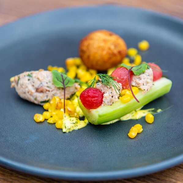 Une assiette contenant un plat, une petite balle et quelques grains de maïs.