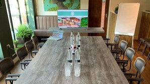 A conference room with a long wooden table, multiple chairs, and a laptop displaying a presentation. - The Royal Oak - Inn (Loughborough)