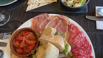A table set with various food items including bread, olives, and charcuterie.