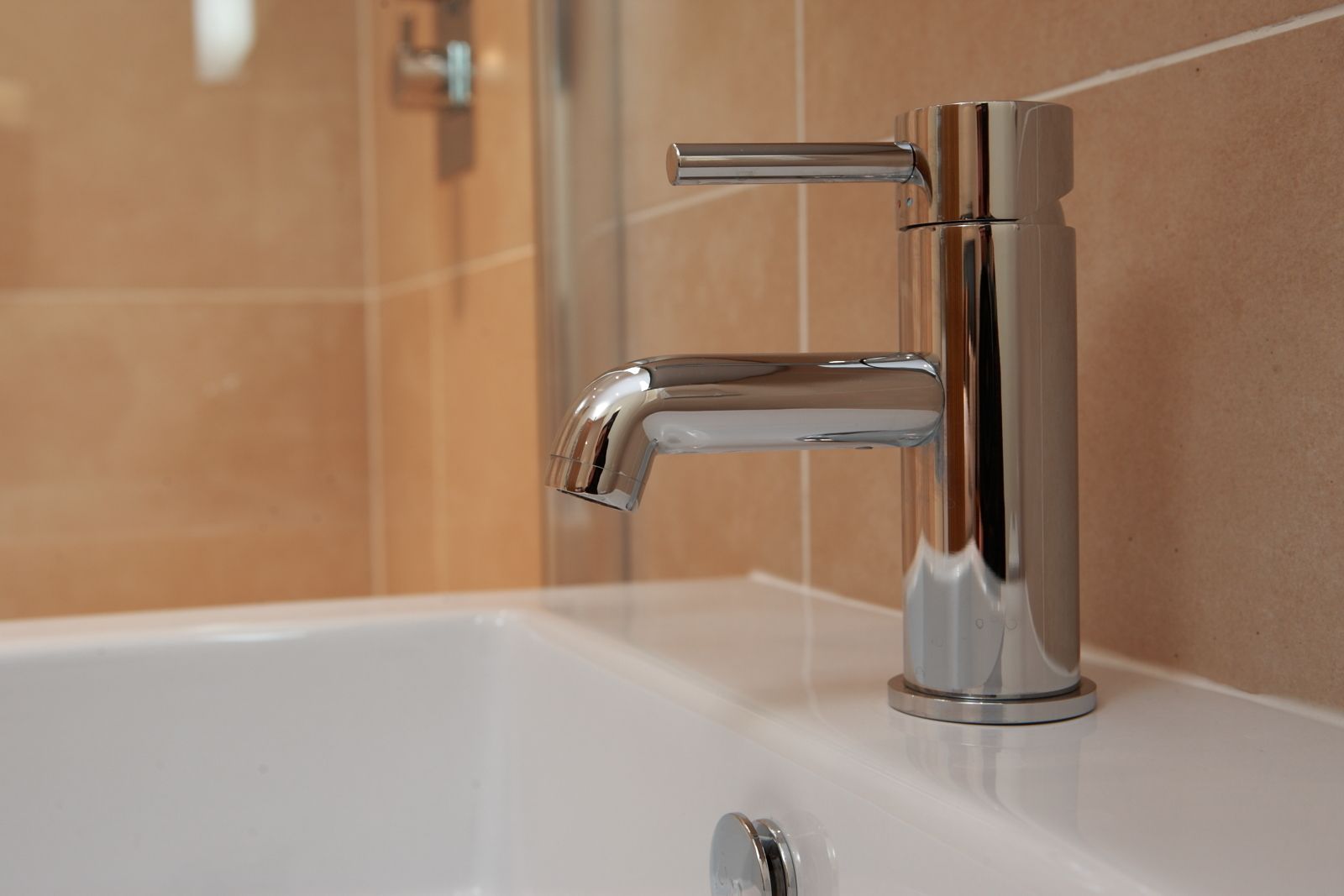 A modern bathroom with a chrome faucet and a white sink.