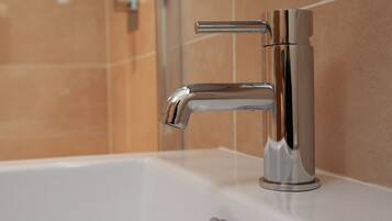 A modern bathroom with a chrome faucet and a white sink.
