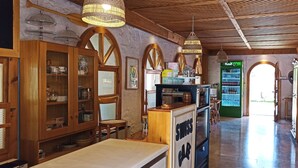 Un café acogedor con decoración de madera, una barra con menú y un dispensador de bebidas verde al fondo.