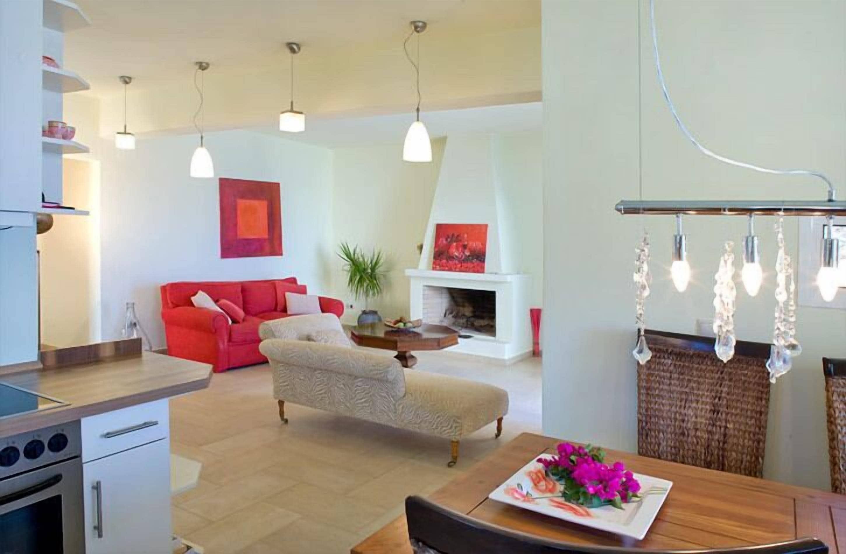 Una cocina moderna con comedor, un sofá rojo y una chimenea.