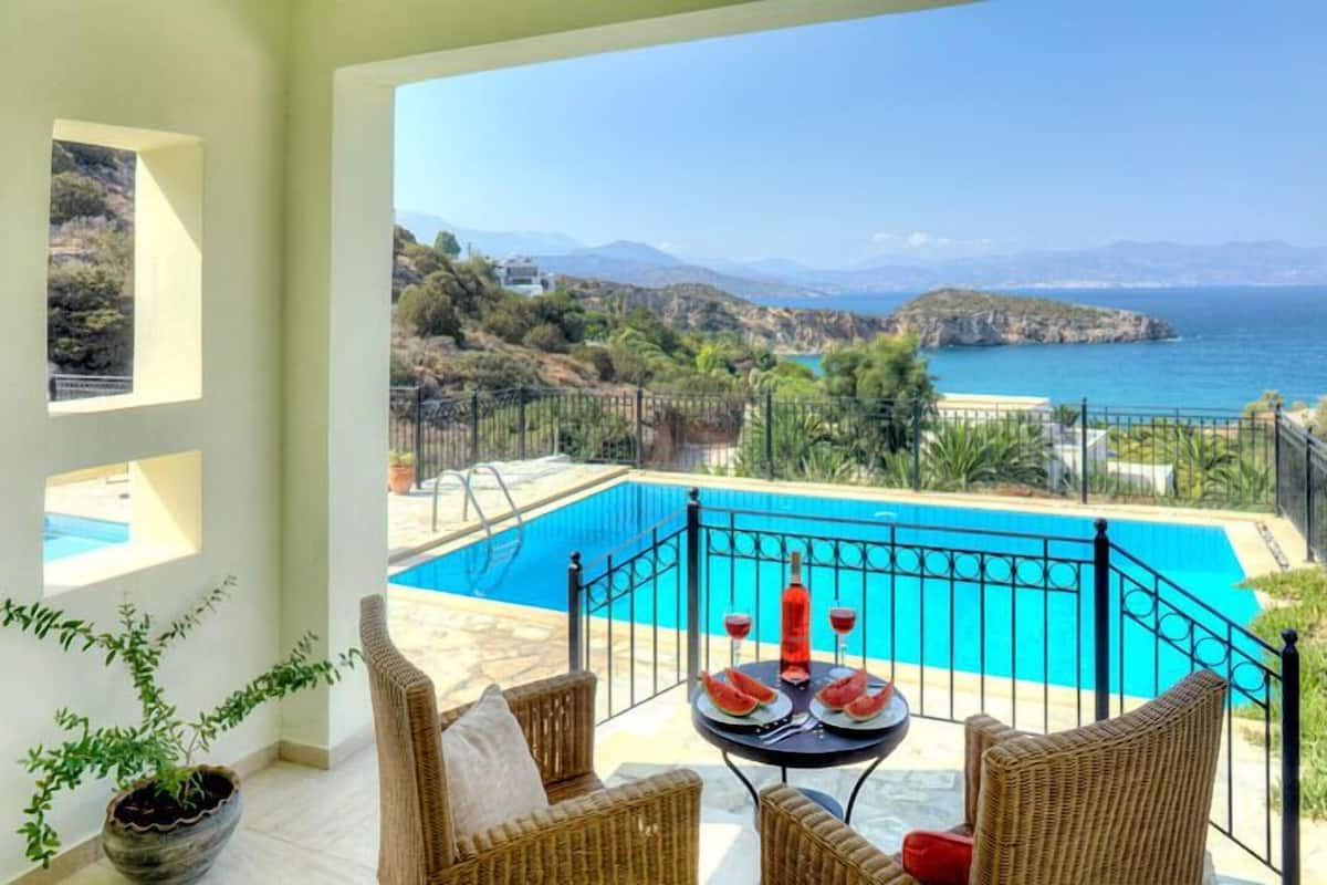 Un balcón con vista a una piscina y al mar.