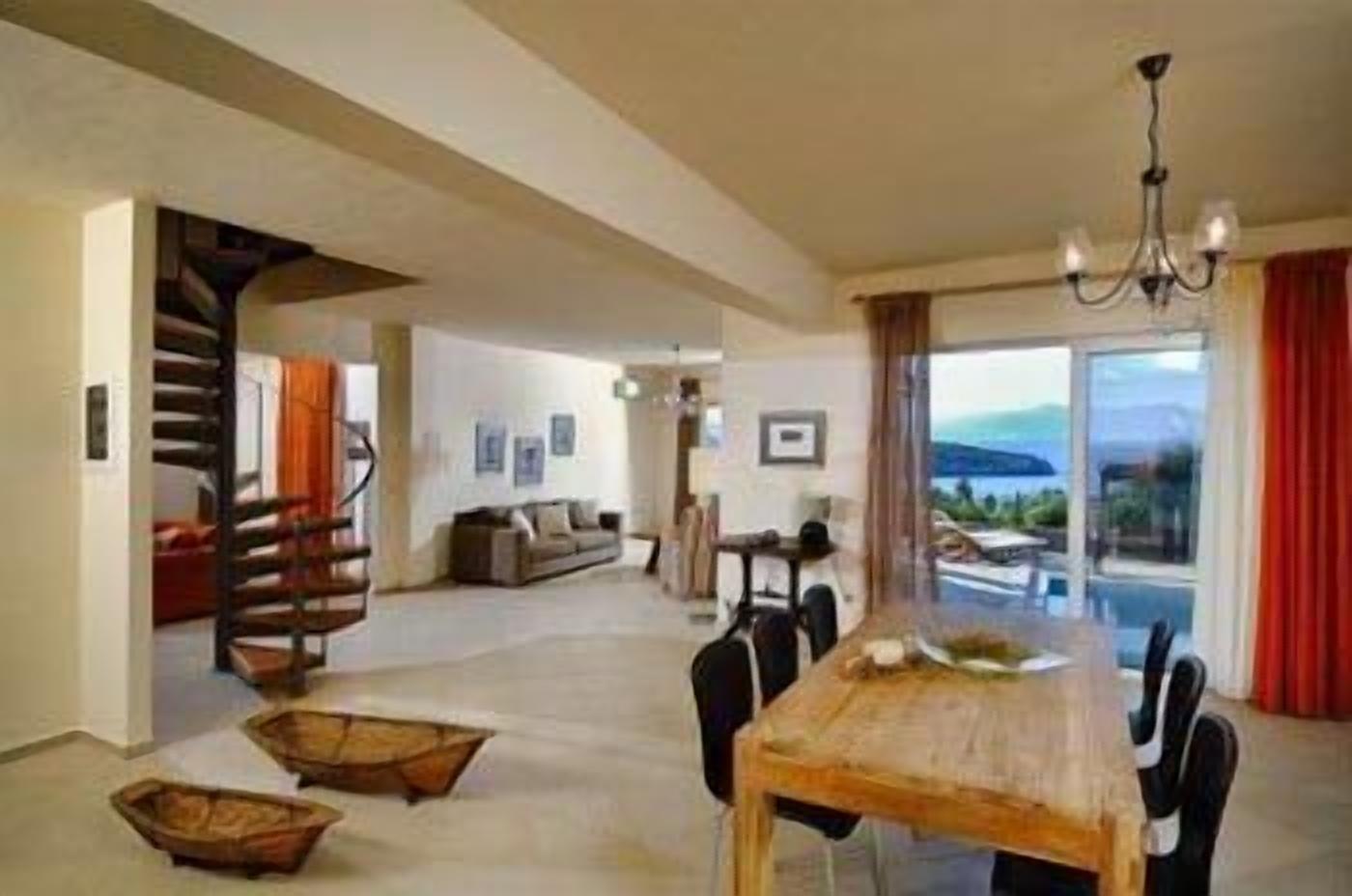 Un grand espace de vie comprenant une table à manger, des chaises, un canapé et un escalier.
