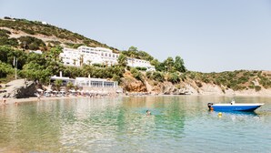 Une station balnéaire dotée d’une plage, d’une piscine et d’un bateau.