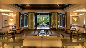 A spacious lobby with a central seating area, large windows, and decorative panels. - Grand Hyatt Goa (Panaji)
