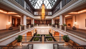 A grand lobby with a central staircase, ornate railings, and a large chandelier. - Grand Hyatt Goa (Panaji)