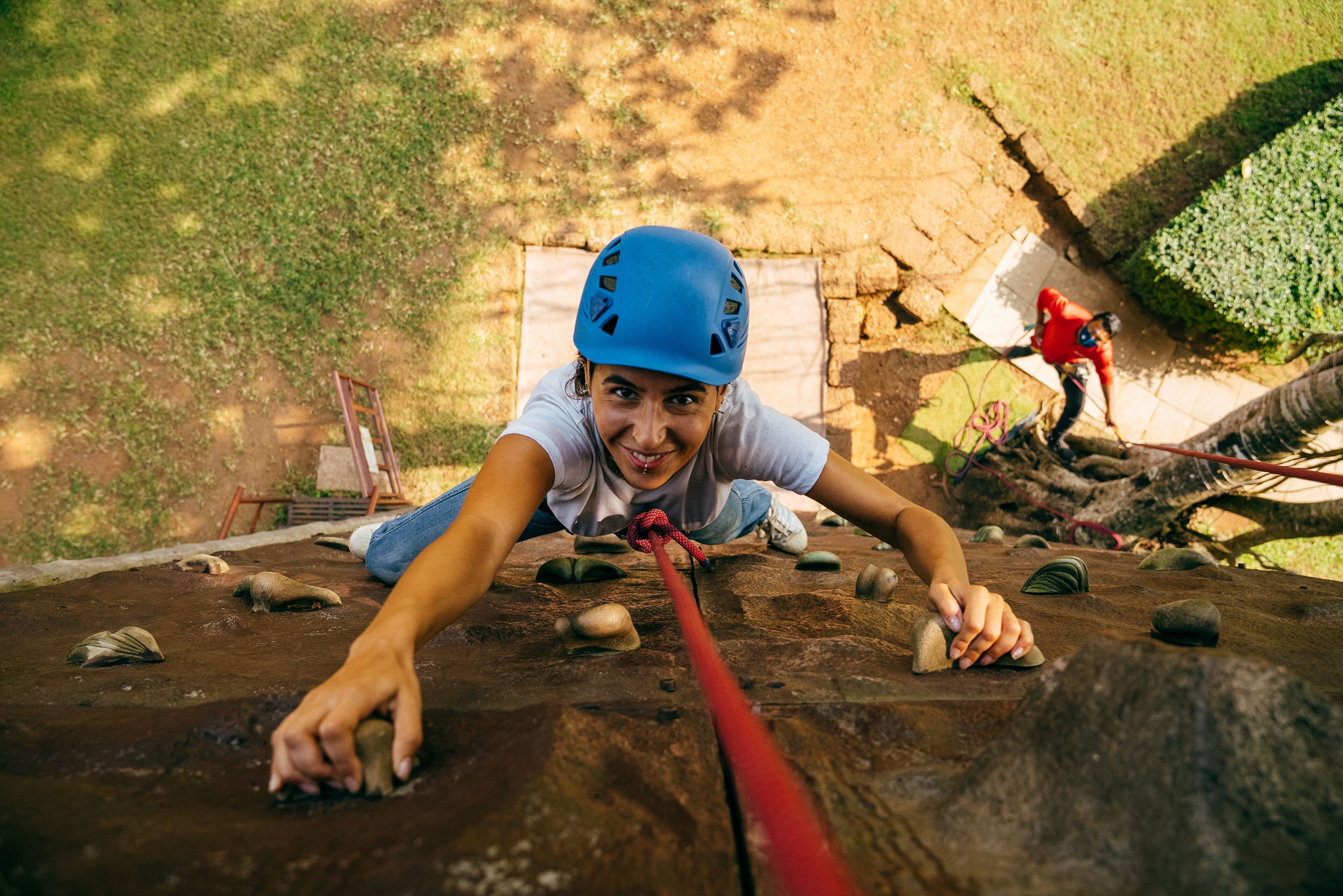 Una persona arrampica una parete rocciosa usando una corda.
