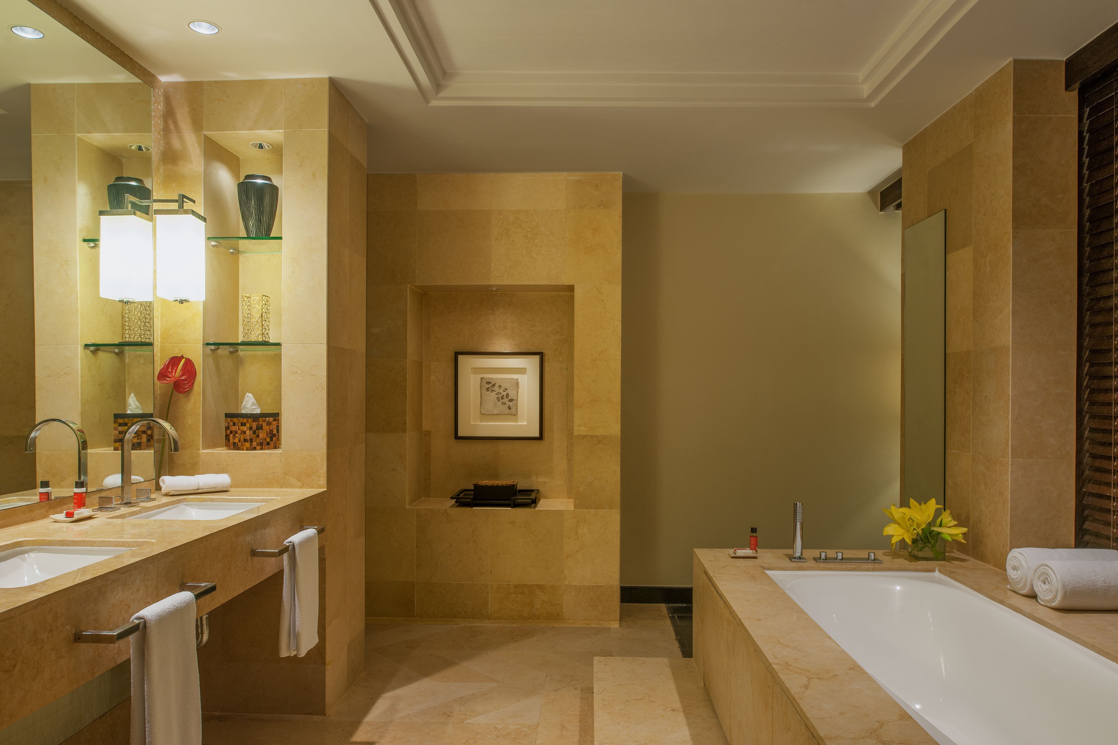 A modern bathroom with a large bathtub, two sinks, and a mirror.