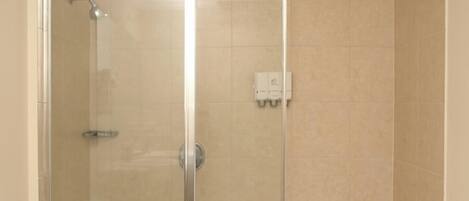 Une salle de bain avec une douche à parois de verre, des toilettes et un lavabo.