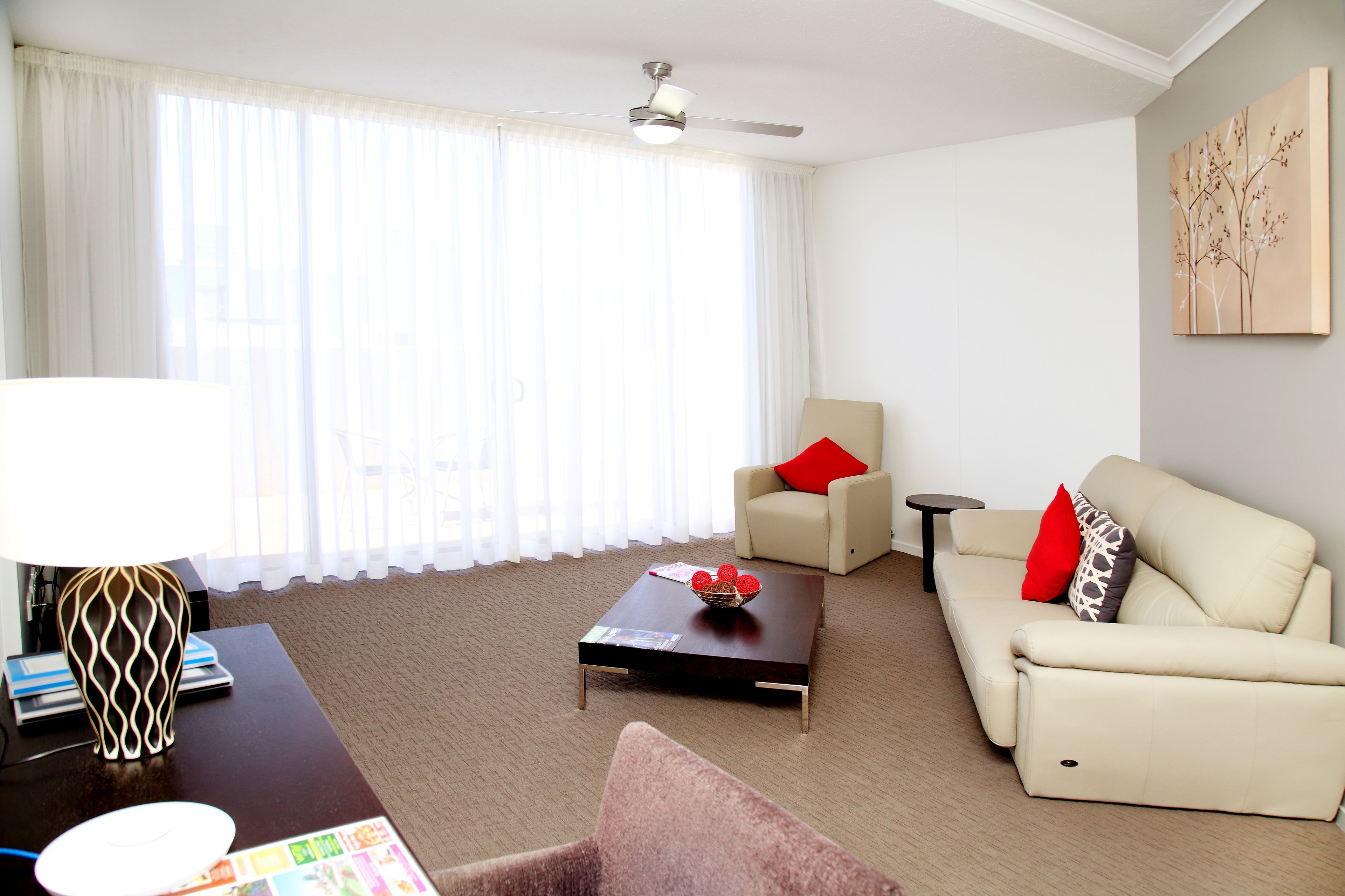 A modern living room with a sofa, a coffee table, and a lamp.