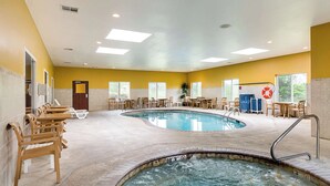 A swimming pool area with multiple seating arrangements and a hot tub.