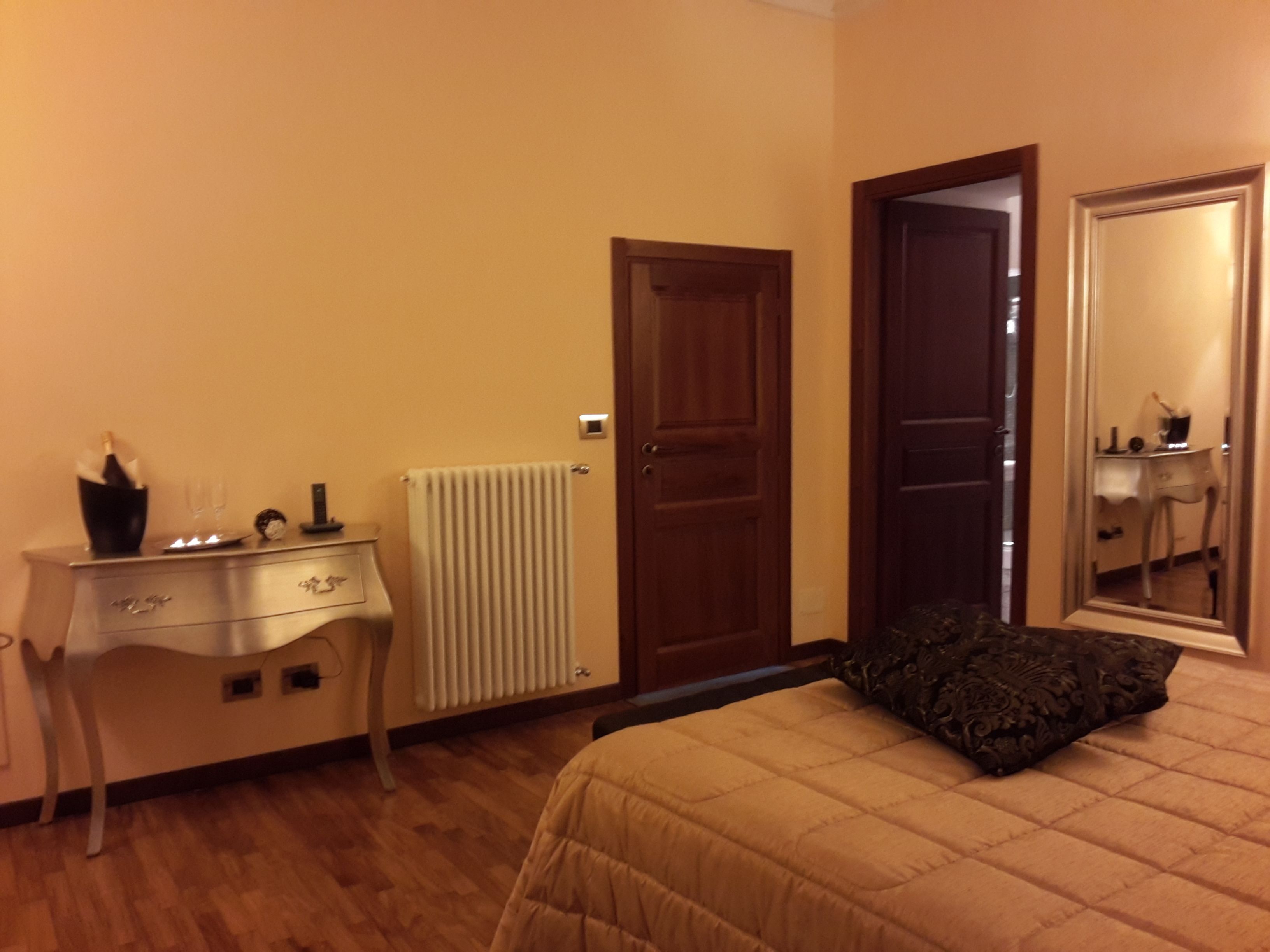 Une chambre à coucher avec un lit, une commode, un radiateur et une porte.