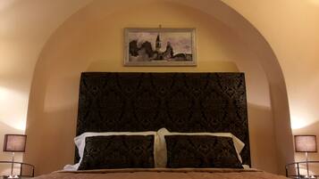 Une chambre à coucher avec un grand lit, une tête de lit décorée et un tableau encadré au-dessus.