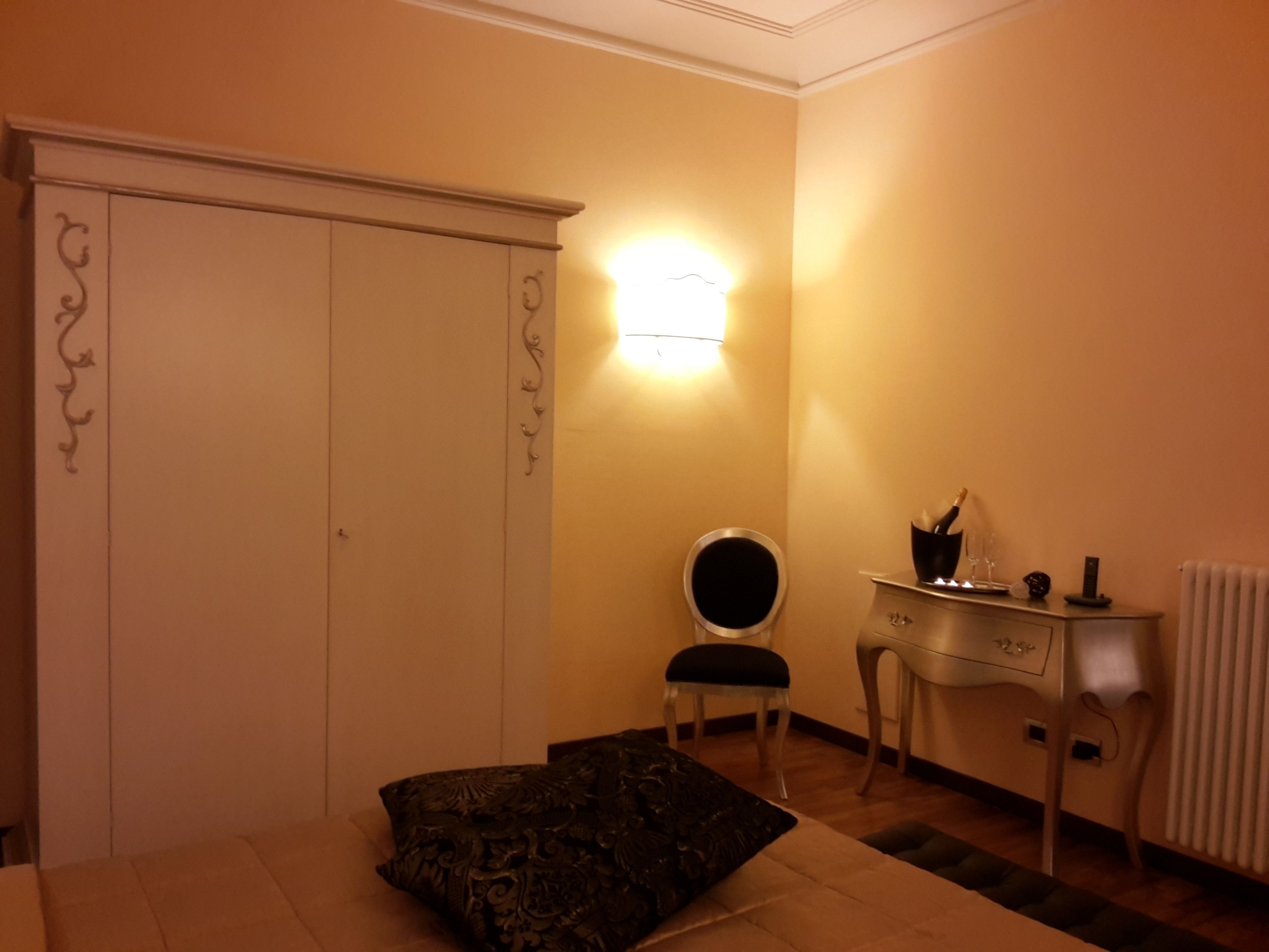 Un dormitorio con cama, armario, escritorio y silla.