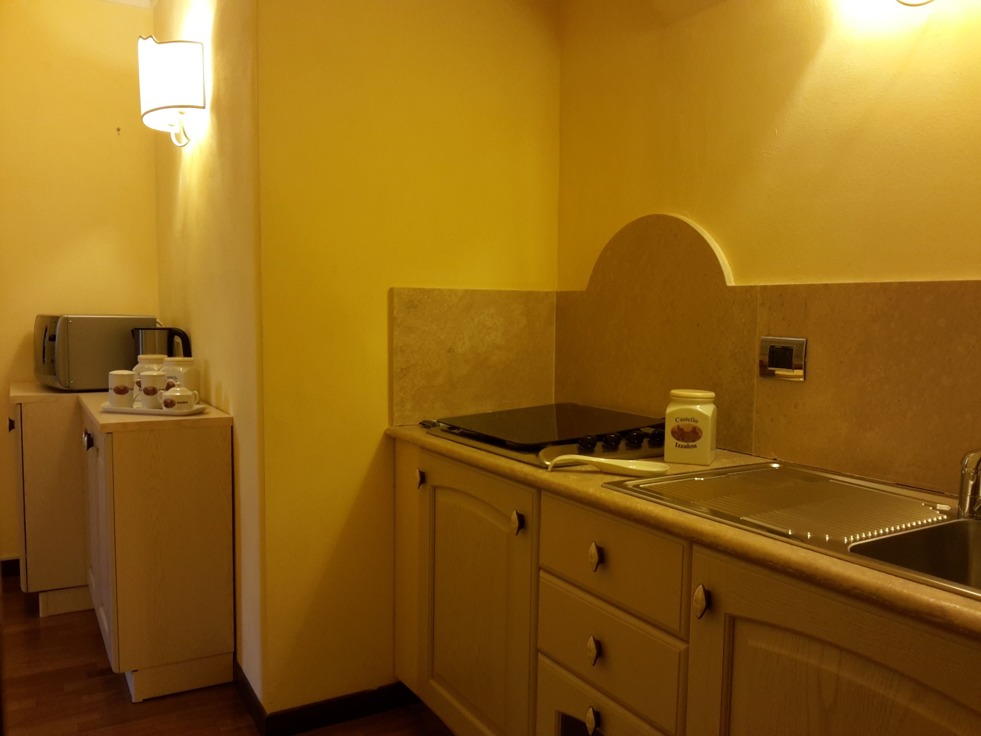 A compact kitchen with a stove, sink, and a small refrigerator.