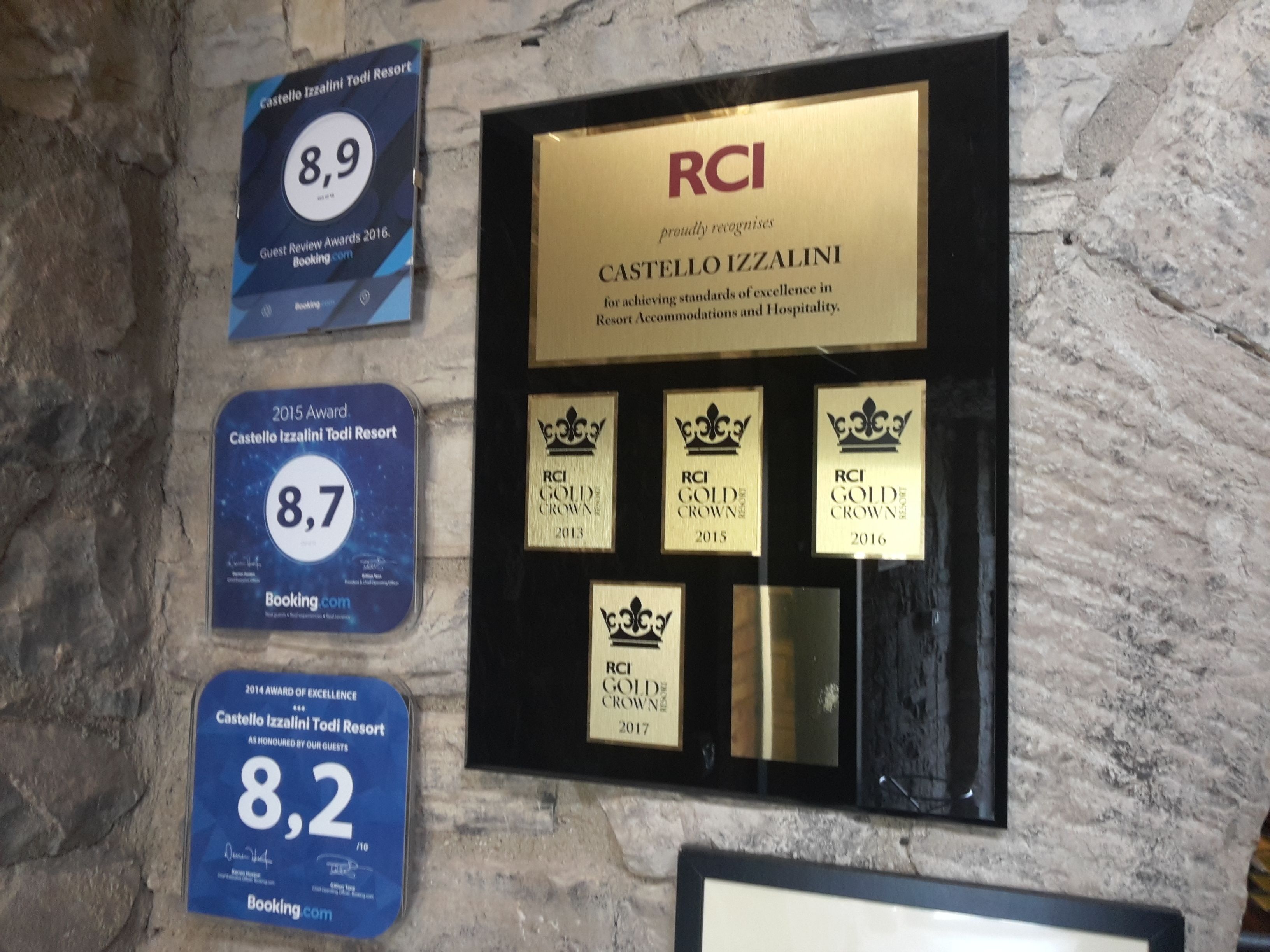 Una parete con riconoscimenti e valutazioni per Castello Izzalini Todi Resort, tra cui i premi RCI Gold Crown dal 2013 al 2017 e un Premio Eccellenza del 2015.