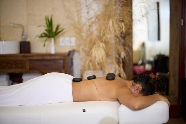 A person receiving a back treatment with hot stones. - Torarica Resort (Paramaribo)