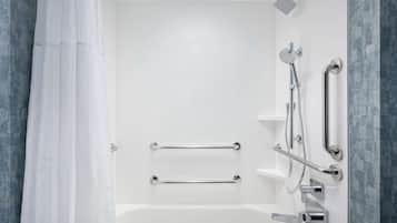 A modern bathroom with a bathtub, grab bars, a showerhead, and a towel rack.
