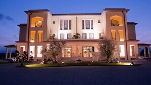 A large, two-story building with a symmetrical facade, multiple windows, and a central entrance with steps.