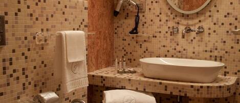 A bathroom with a bidet, a sink, and a mirror.