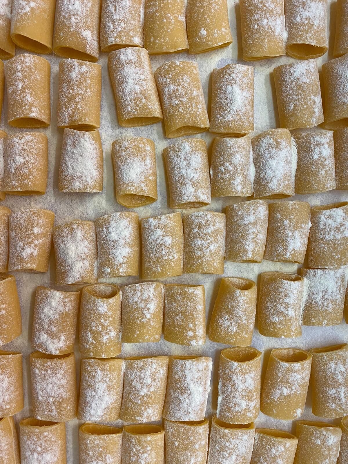 A wall of uniformly arranged, cylindrical objects dusted with a white powder, likely a food item.