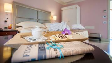 Ein Hotelzimmer mit einem Bett, einem Nachttisch mit Tasse, einem Teller mit Essen und einer Zeitung.