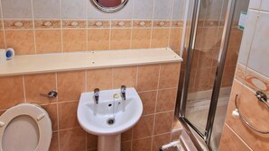 A bathroom with a toilet, sink, and shower. - The Albany Hotel (Blackpool)