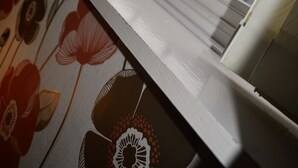 A window with a grid pattern, a white window frame, and a floral wallpaper pattern. - The Albany Hotel (Blackpool)