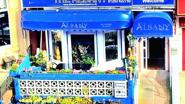 A hotel entrance with a blue awning displaying "The Albany" and "Welcome" signs. - The Albany Hotel (Blackpool)