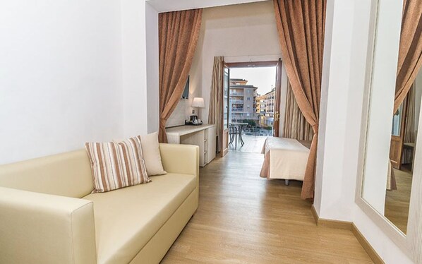 Relax in a stylish room with a neutral-toned sofa, city views, and a desk area.