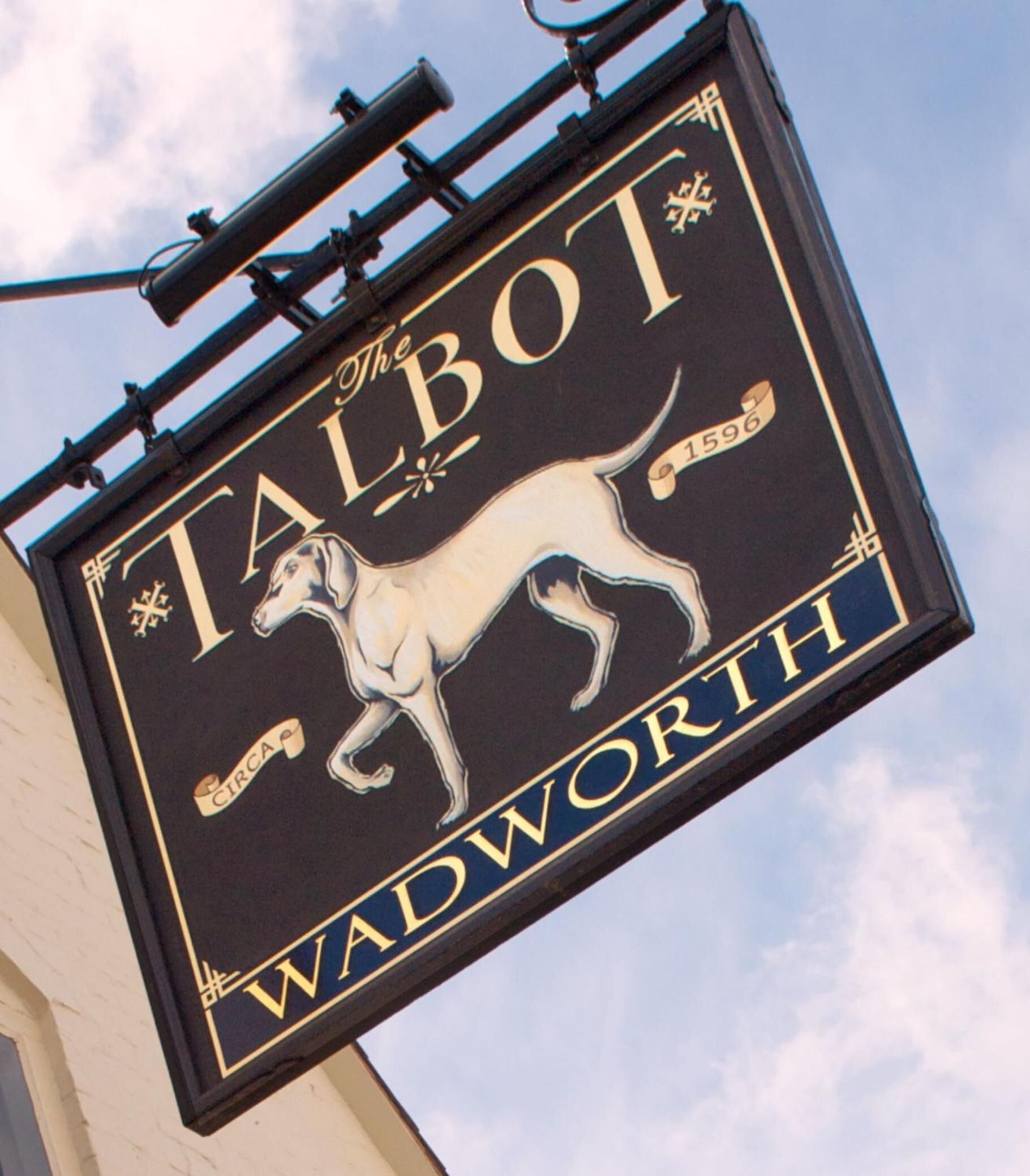 En skylt för puben ”The Talbot” i Wadworth, med en illustration av en hund och pubens namn.