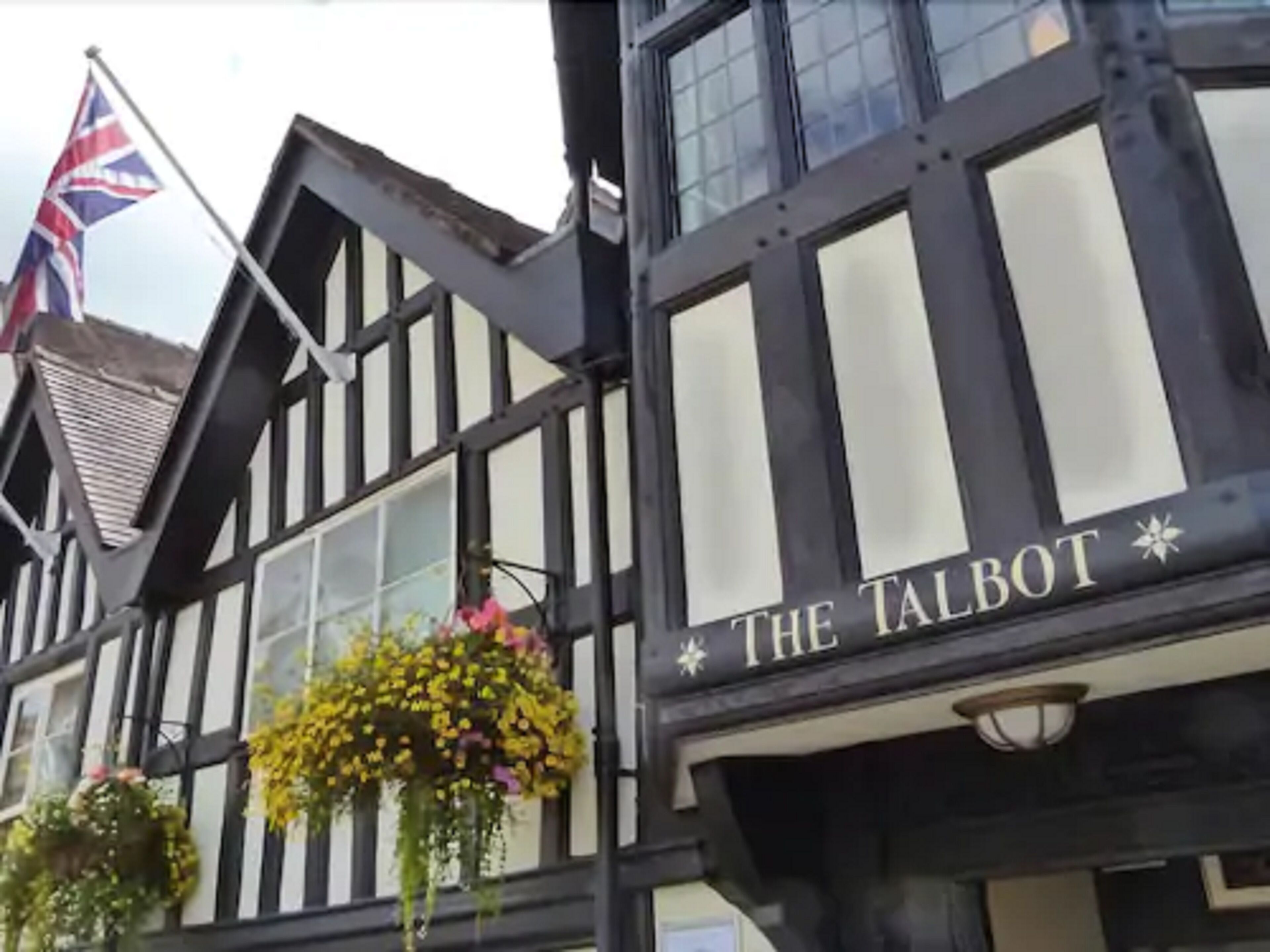 A traditional black and white timber-framed building with a sign reading "THE TALBOT".