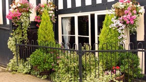 A black and white striped building with a window and a metal fence. - The Talbot Inn (Ledbury)